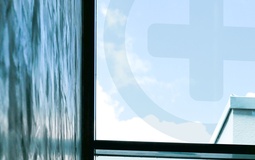 Foto: Logo auf Fenster mit Himmel im Hintergrund