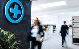 Foto: Büroleben, 2 Personen laufen durchs Bild